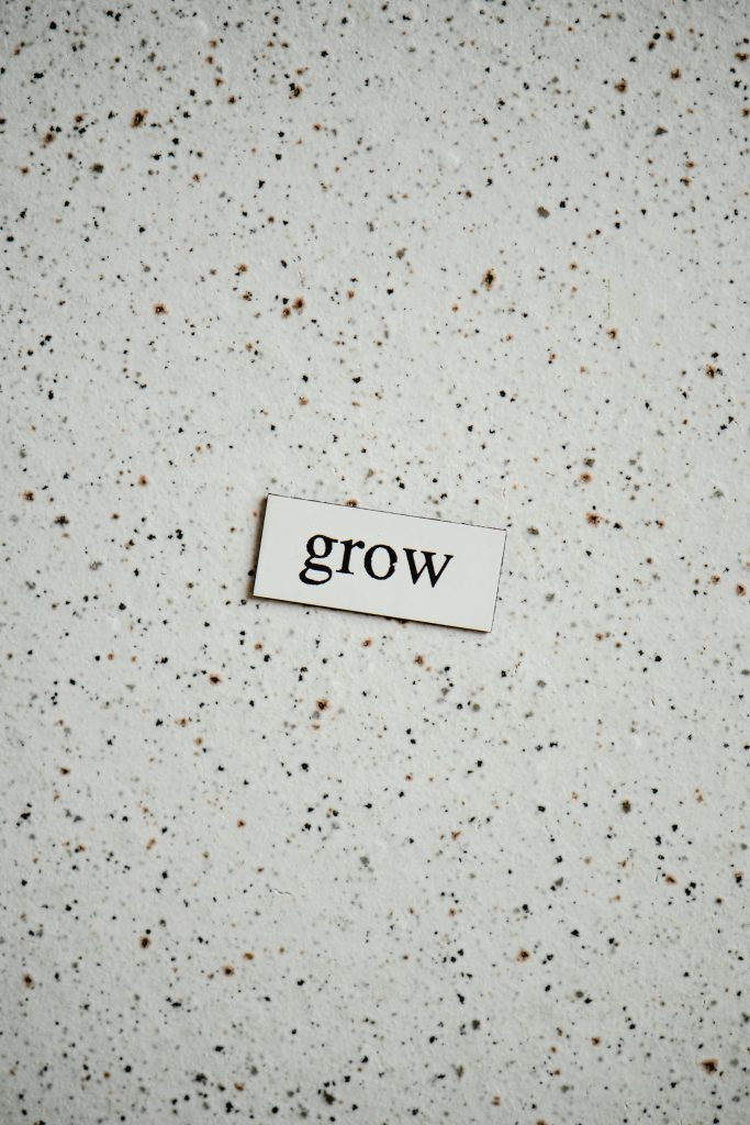 Minimalist background with the word "grow" on a speckled surface, inspiring growth and potential.